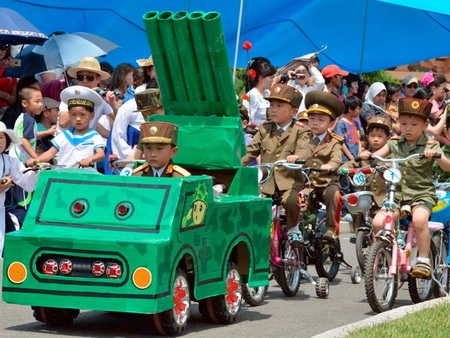 В Пхеньяне прошел детский военный парад с игрушечными ракетами и стрельбой по американцам (Видео)